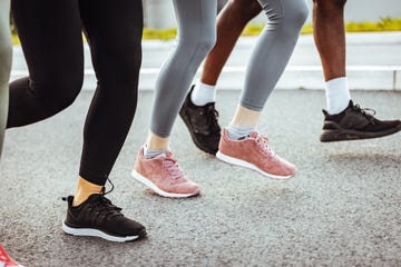 legs and shoes of young adults running in the city.